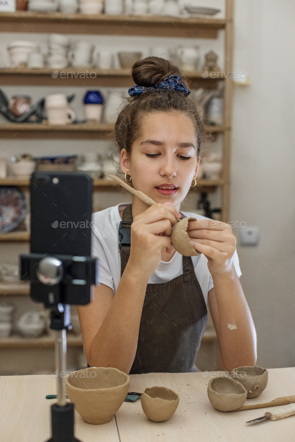 Beautiful teenage girl playing with modeling clay in pottery Craft and clay art